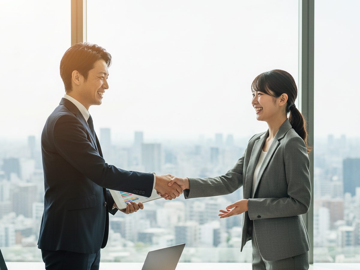 大阪の製造業経営者と笑顔で握手する社労士。労務体制の見直しにより年間1,000万円以上のコスト削減を実現した成功事例イメージ